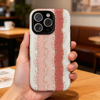 Phone case with vertical pink floral stripes on a blurred background.