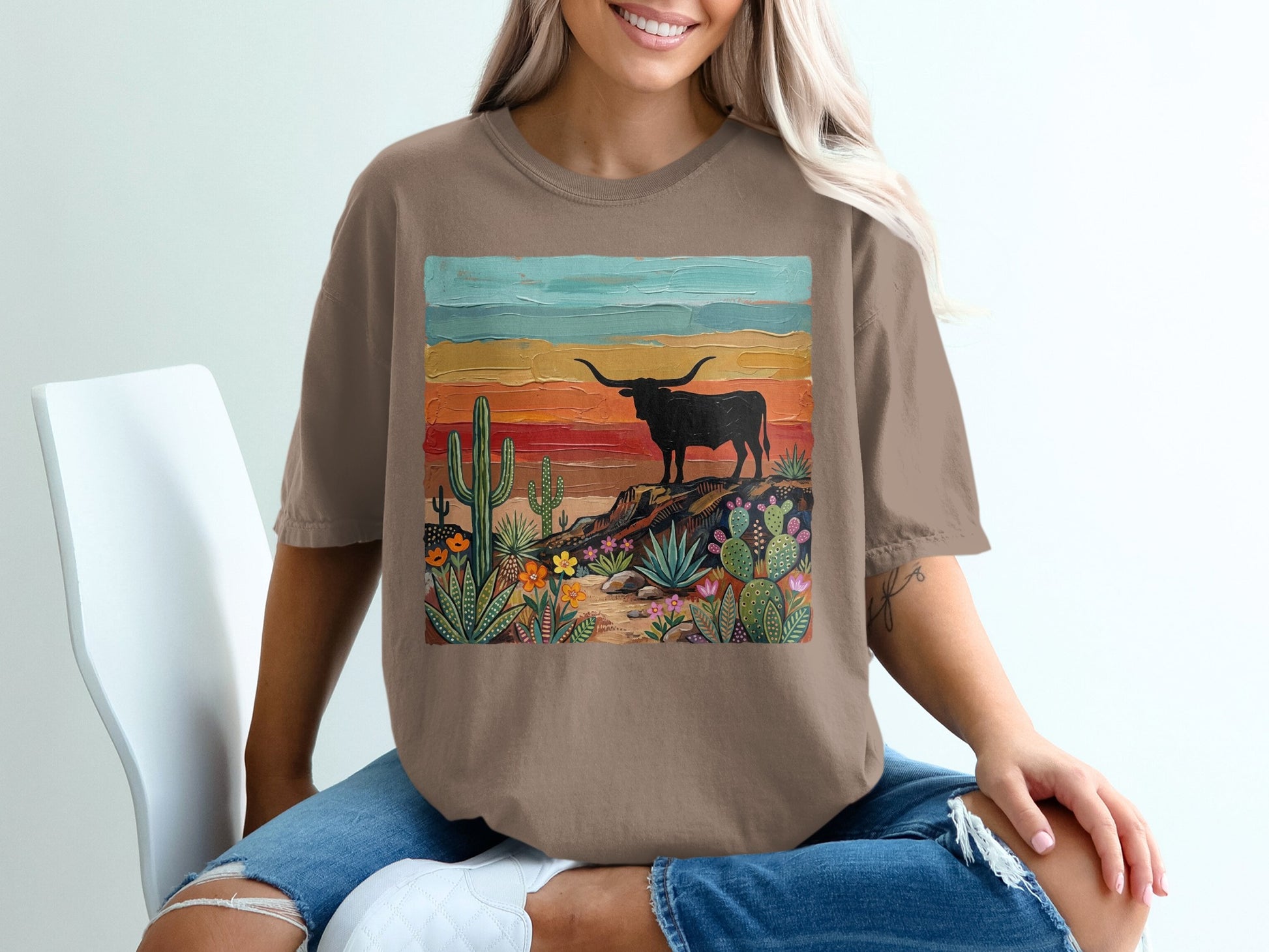 Brown t-shirt featuring a desert landscape with a longhorn cattle silhouette.