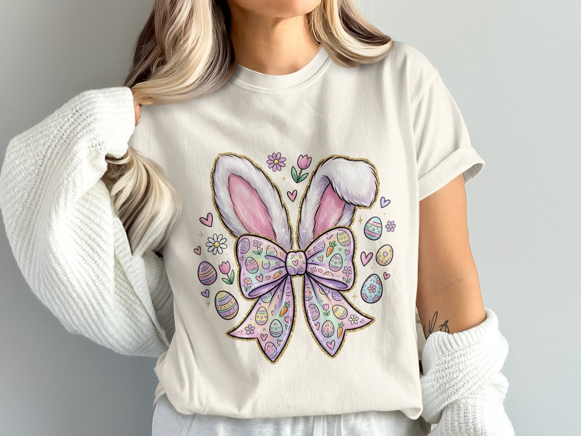 White t-shirt with pastel Easter bunny ears and bow with decorated eggs.