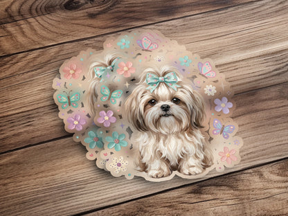 Fluffy white Shih Tzu puppy with blue bow sits among flowers and butterflies.