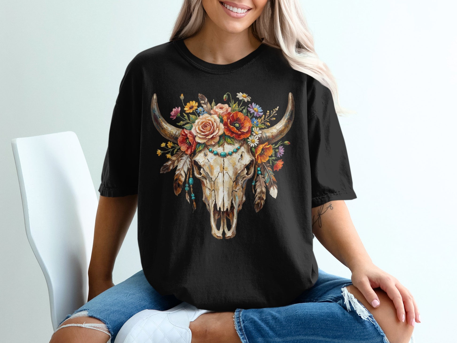 Black t-shirt with a distressed steer skull adorned with colorful flowers and feathers.