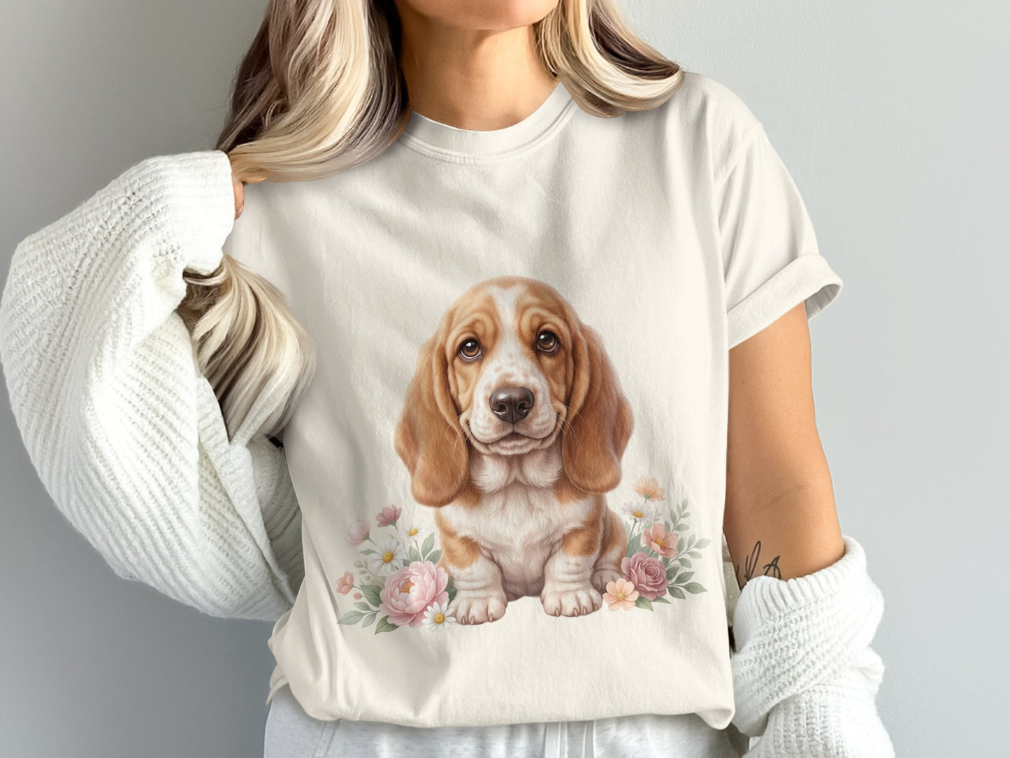 Cream t-shirt with a watercolor painting of a basset hound puppy and pink flowers.