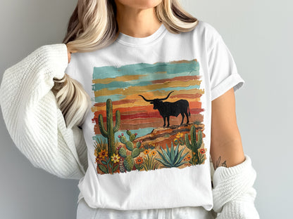 White t-shirt with desert landscape, cactus, and longhorn bull graphic.
