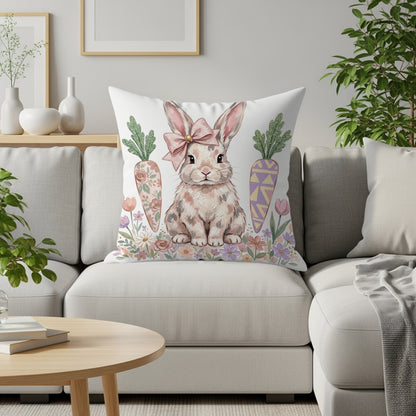 Bunny wearing a pink bow sits on a couch with carrots and flowers.