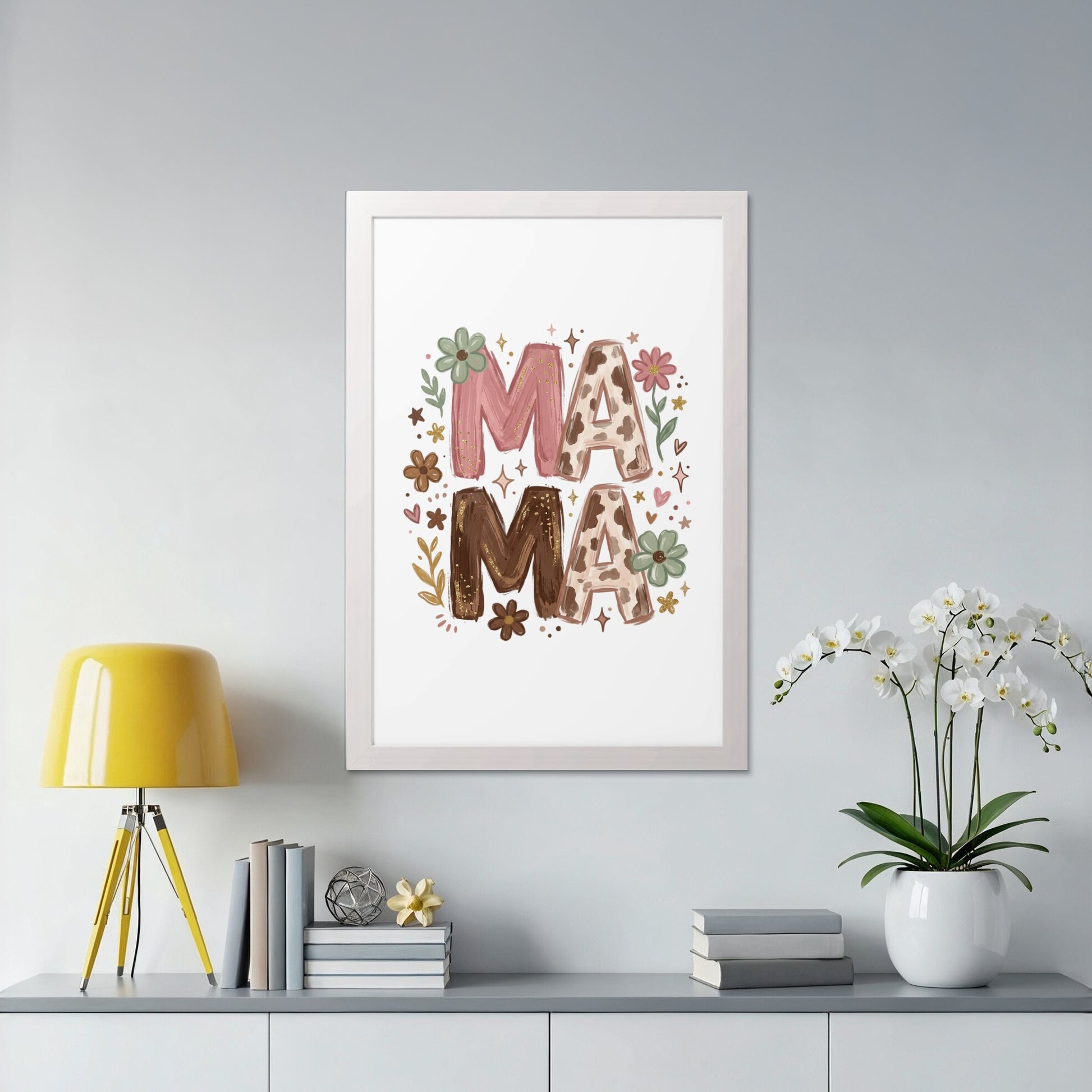 Framed artwork with "MAMA" in floral and cow print, displayed on a shelf.