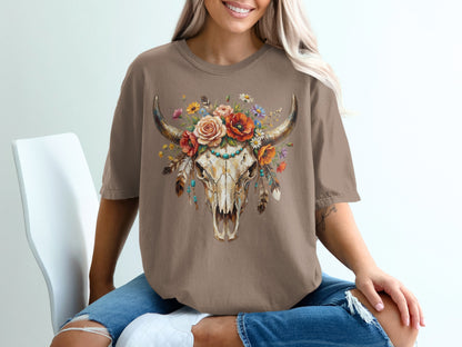 Brown t-shirt with a distressed bull skull adorned with colorful flowers and feathers.
