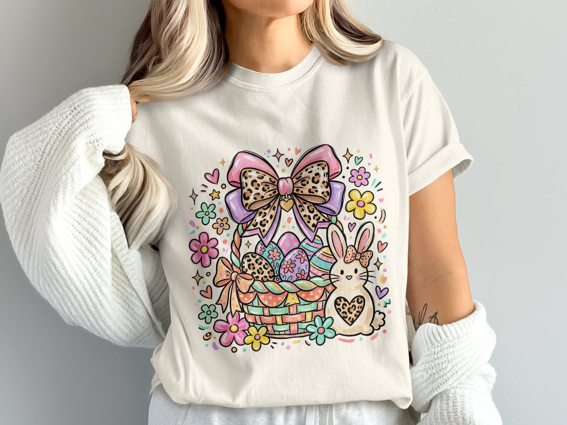 Easter basket with eggs, bunny, bow, and flowers on a cream t-shirt.