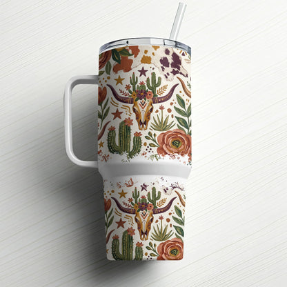 Cow print tumbler with cacti, cow skull, and floral desert pattern.