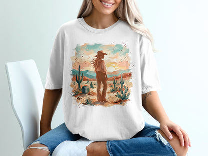 Woman in cowboy hat standing in desert landscape graphic tee.