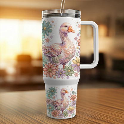 White tumbler with pastel duck and floral design, featuring a handle.