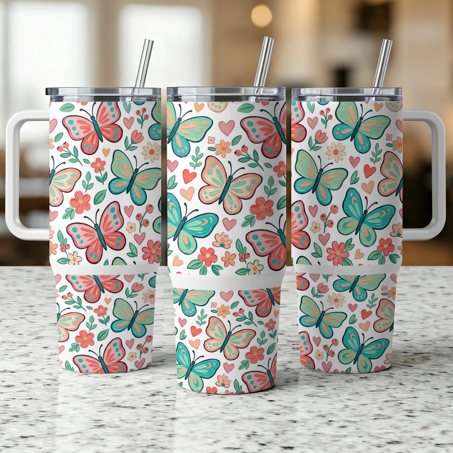 Three tumblers with butterfly and floral patterns, featuring white handles and straws.