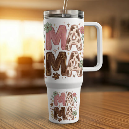 Floral mama tumbler with straw on a wooden surface.