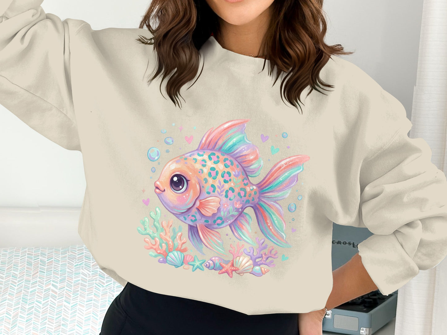Pastel fish with colorful scales on coral and seashells, on a cream sweatshirt.
