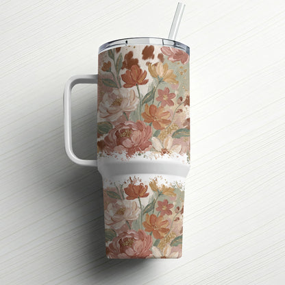Floral pattern travel tumbler with handle and straw.