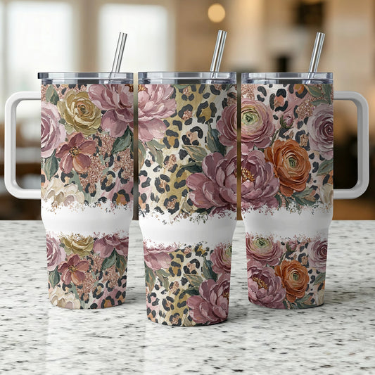 Three tumblers with floral and leopard print designs, standing on a countertop.