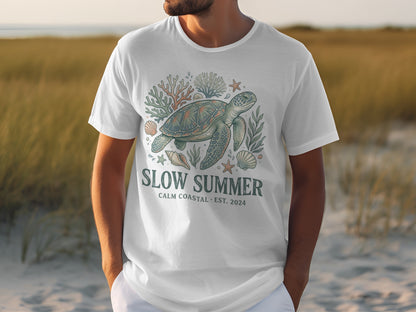 White t-shirt with sea turtle, coral, and shells graphic.