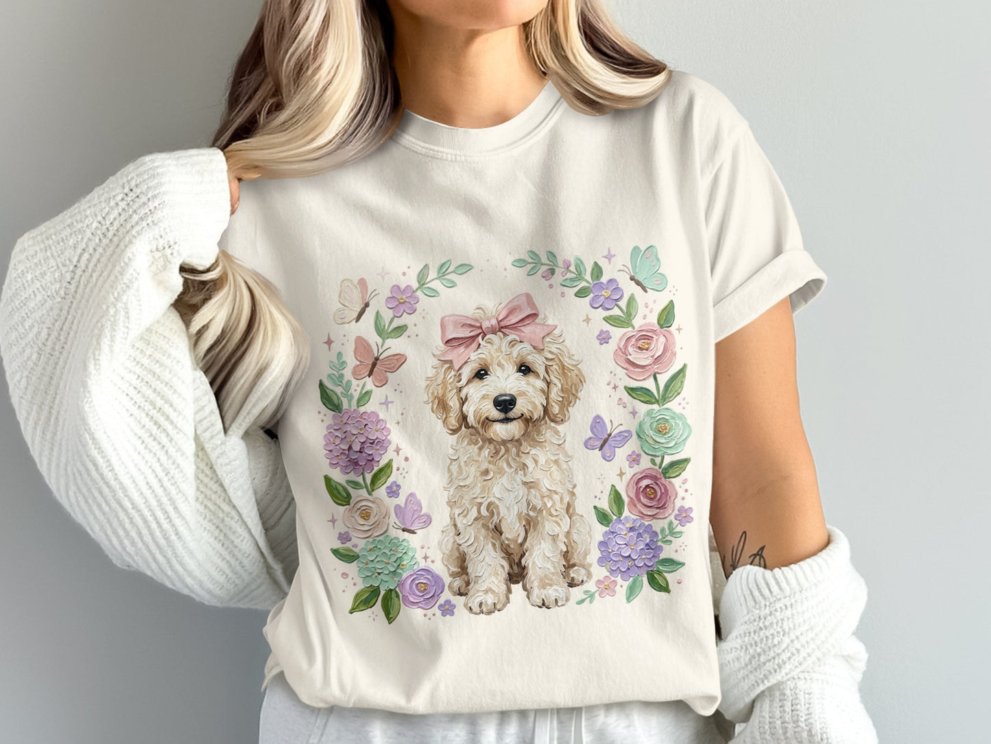 Cream t-shirt with a fluffy dog surrounded by a floral wreath and butterflies.