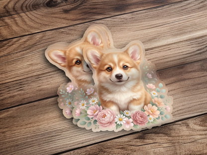 Two corgis peeking through a floral wreath on a wooden background.