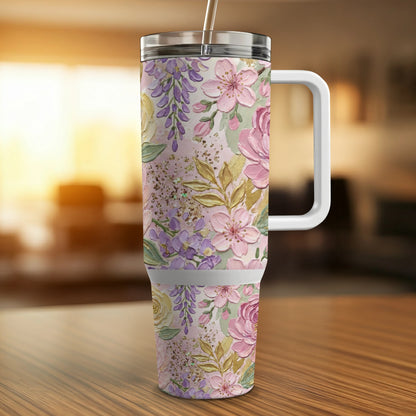 Floral tumbler with handle and straw on a wooden table.