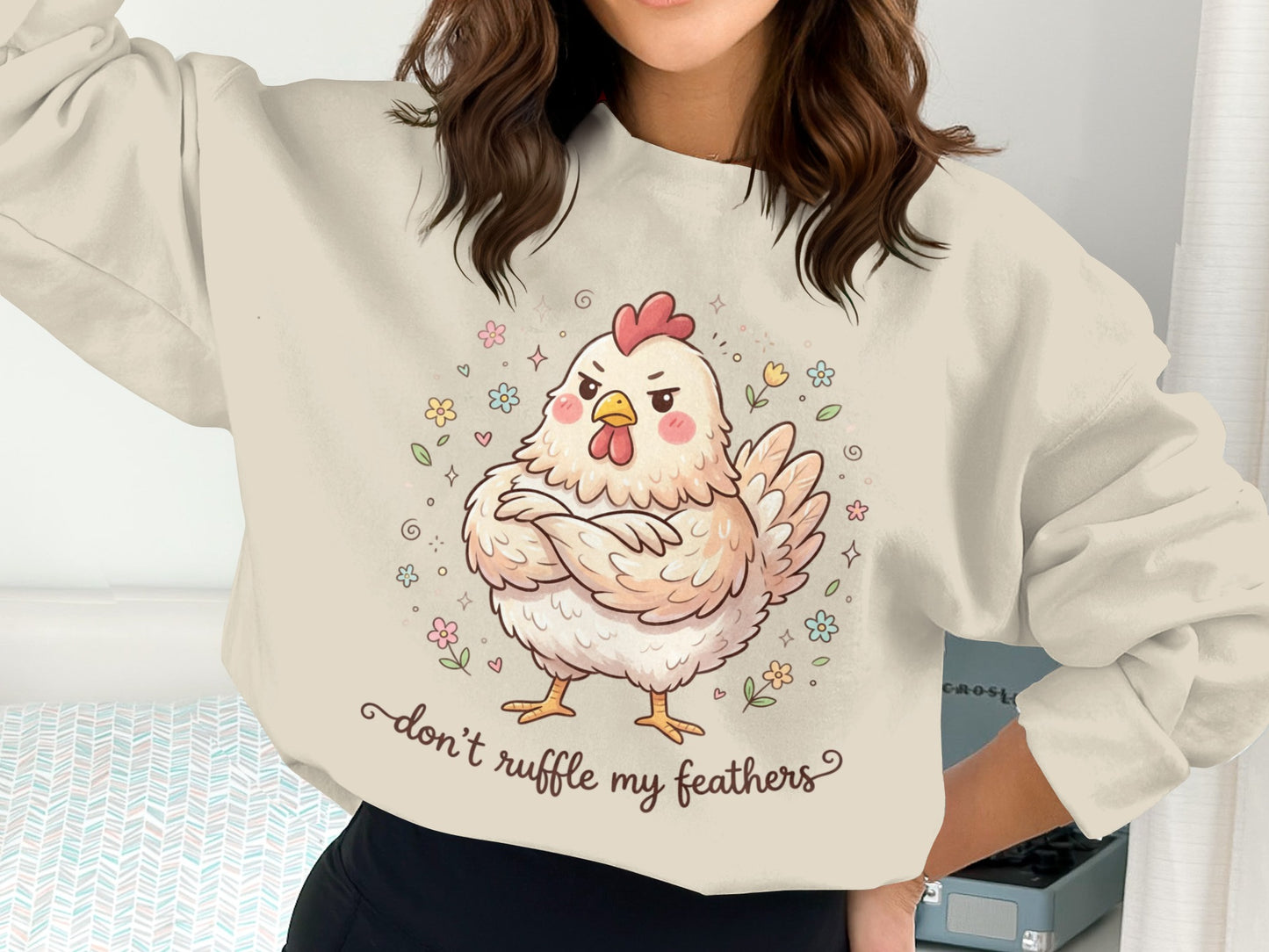 Cream sweatshirt with a grumpy cartoon chicken and floral accents.