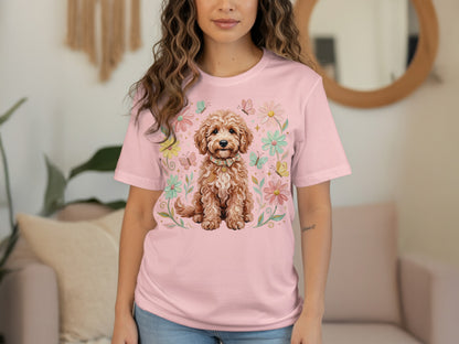 Pink t-shirt with a smiling doodle dog surrounded by flowers and butterflies.