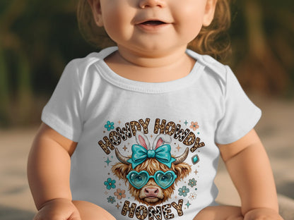 Baby in white onesie with "Howdy Honey" and a cow wearing heart sunglasses.