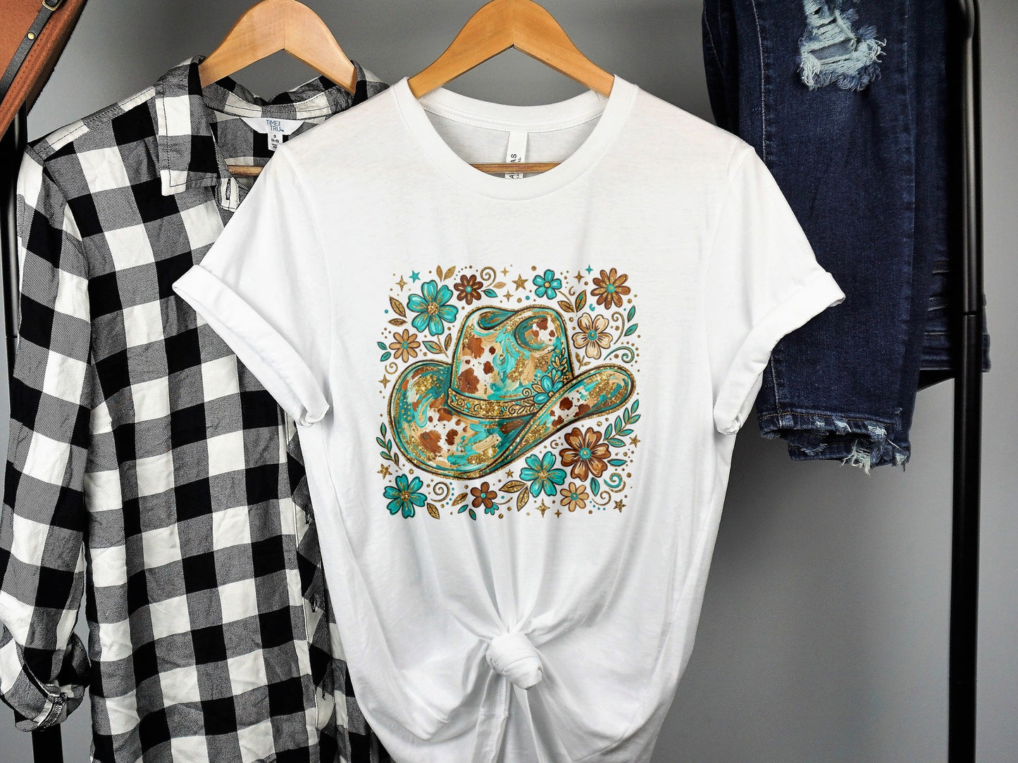 White t-shirt with cowboy hat and floral design.