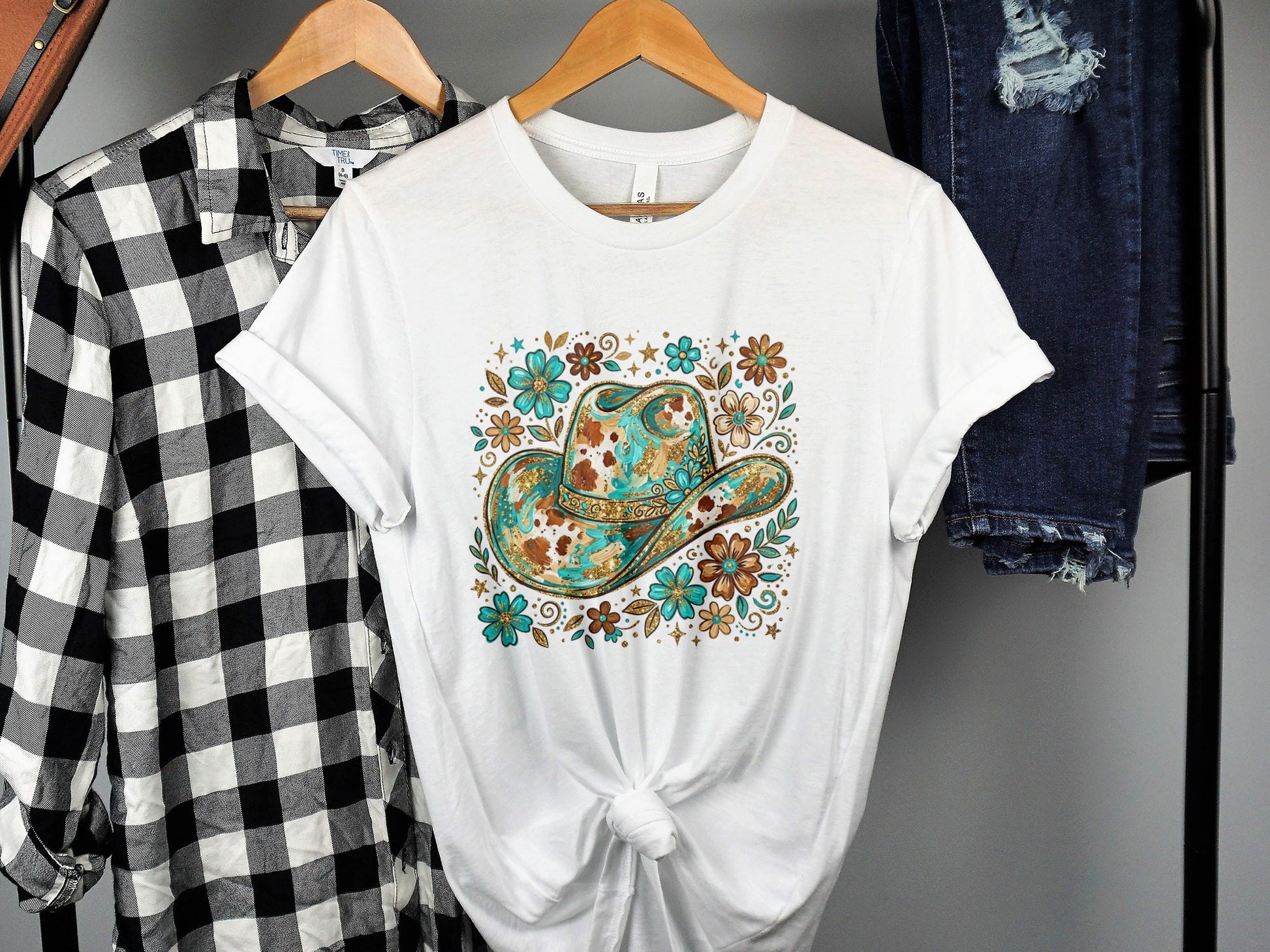 White t-shirt with cowboy hat and floral design.