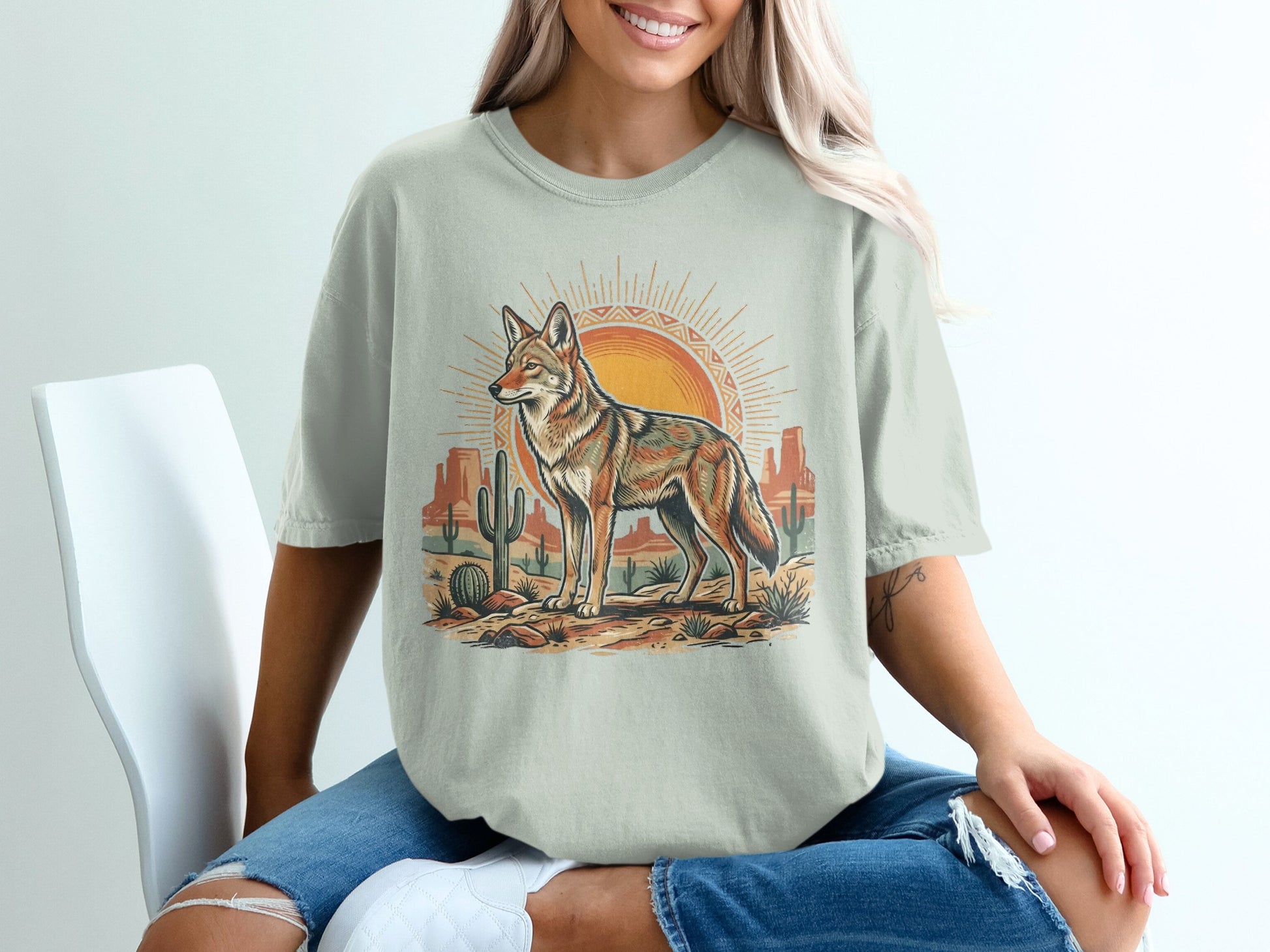 Desert coyote with sun and cacti graphic on a light beige t-shirt.