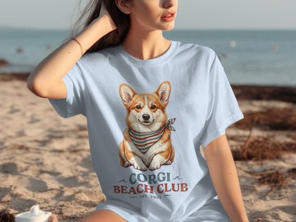 Light blue t-shirt with a corgi wearing a bandana and "Corgi Beach Club EST. 2023" text.