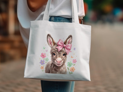 White tote bag featuring a cute donkey wearing a pink bow and surrounded by flowers.