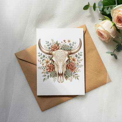 Card with decorative bull skull and floral art over a brown envelope.