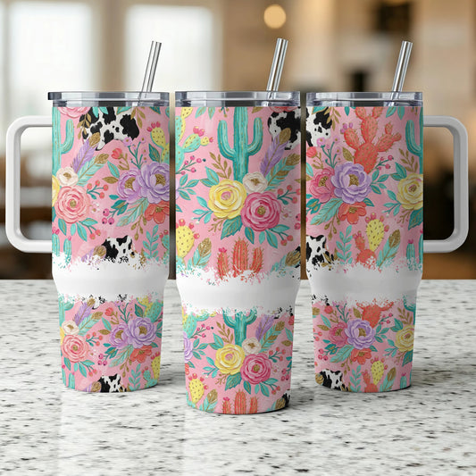 Three floral and cactus tumblers with cow print details and metal straws.