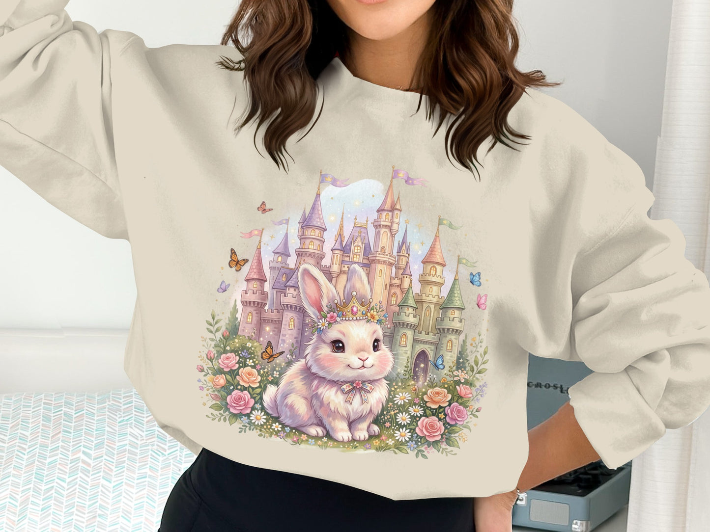 Cream sweatshirt with whimsical bunny, castle, and floral illustration.