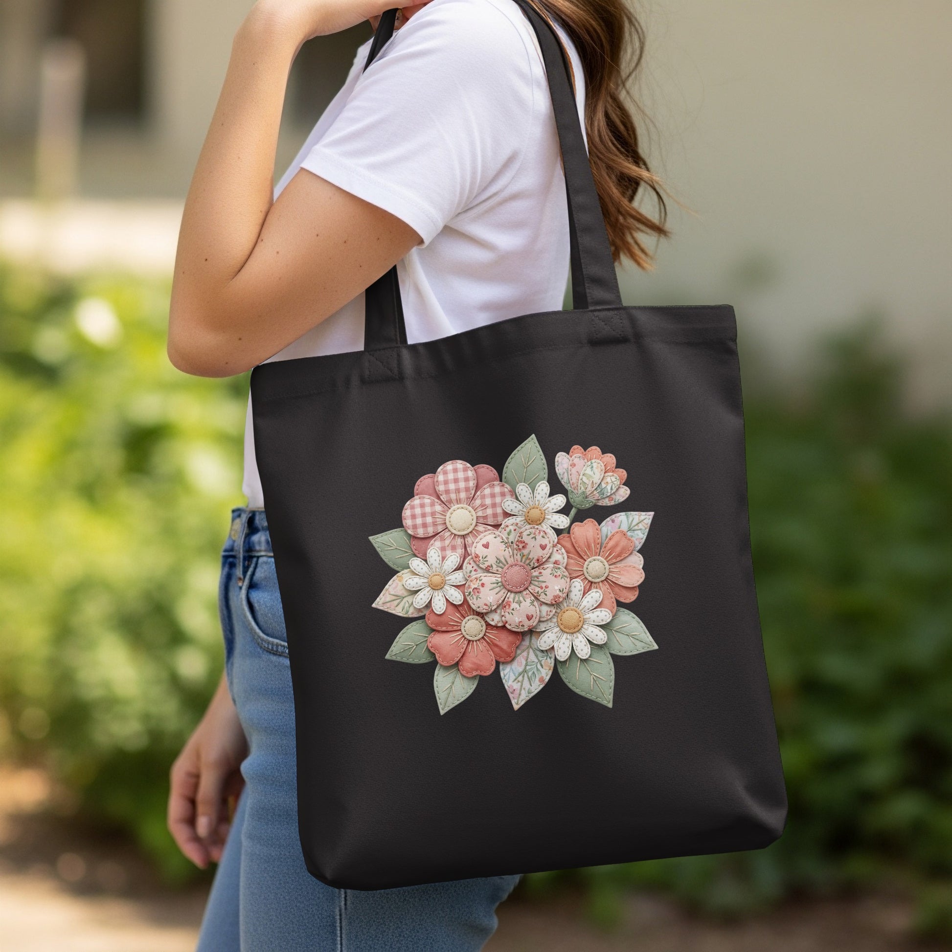 Black tote bag with a floral applique design.
