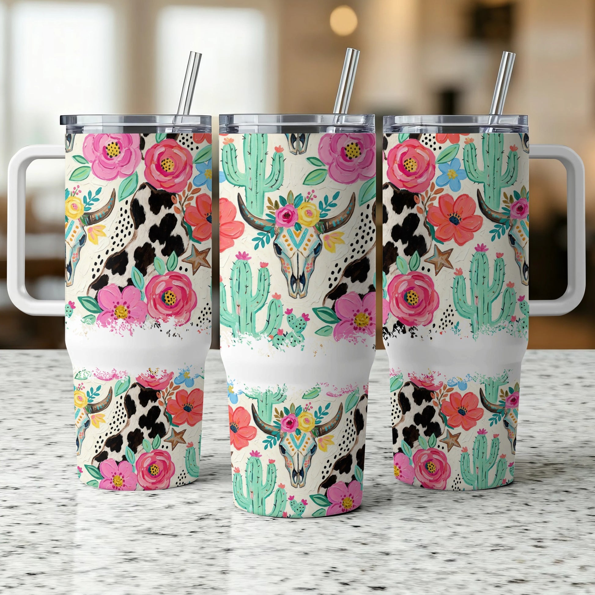Three tumblers with cow print, cactus, and floral skull designs.