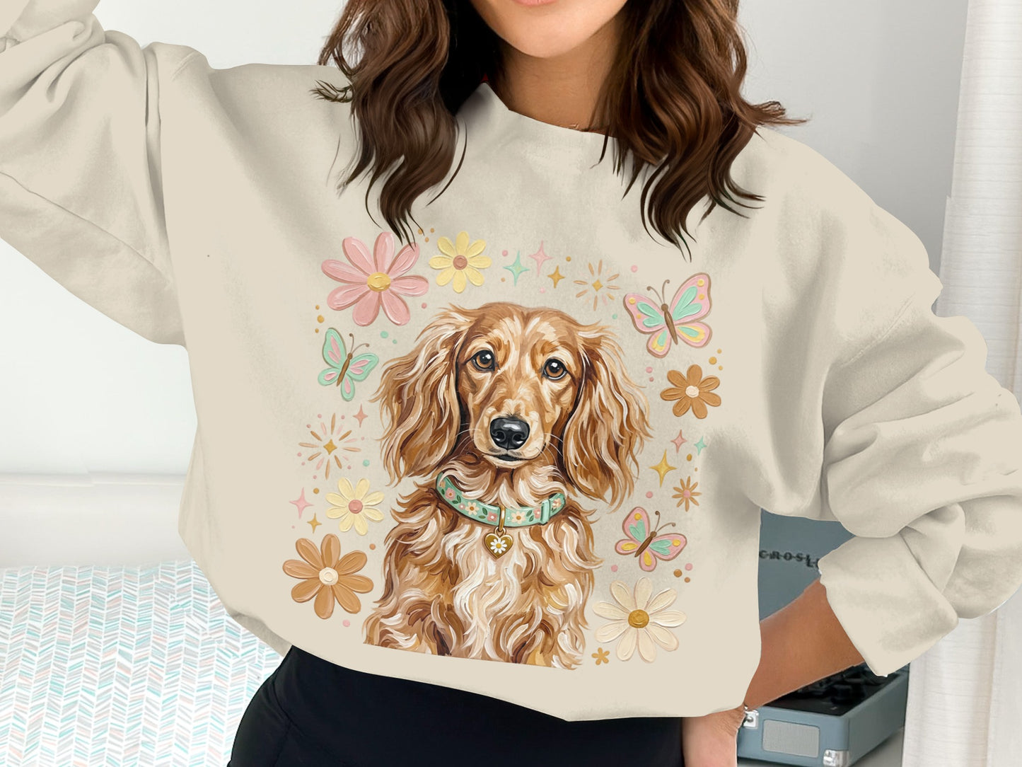 Crewneck sweatshirt with dachshund illustration and floral accents.