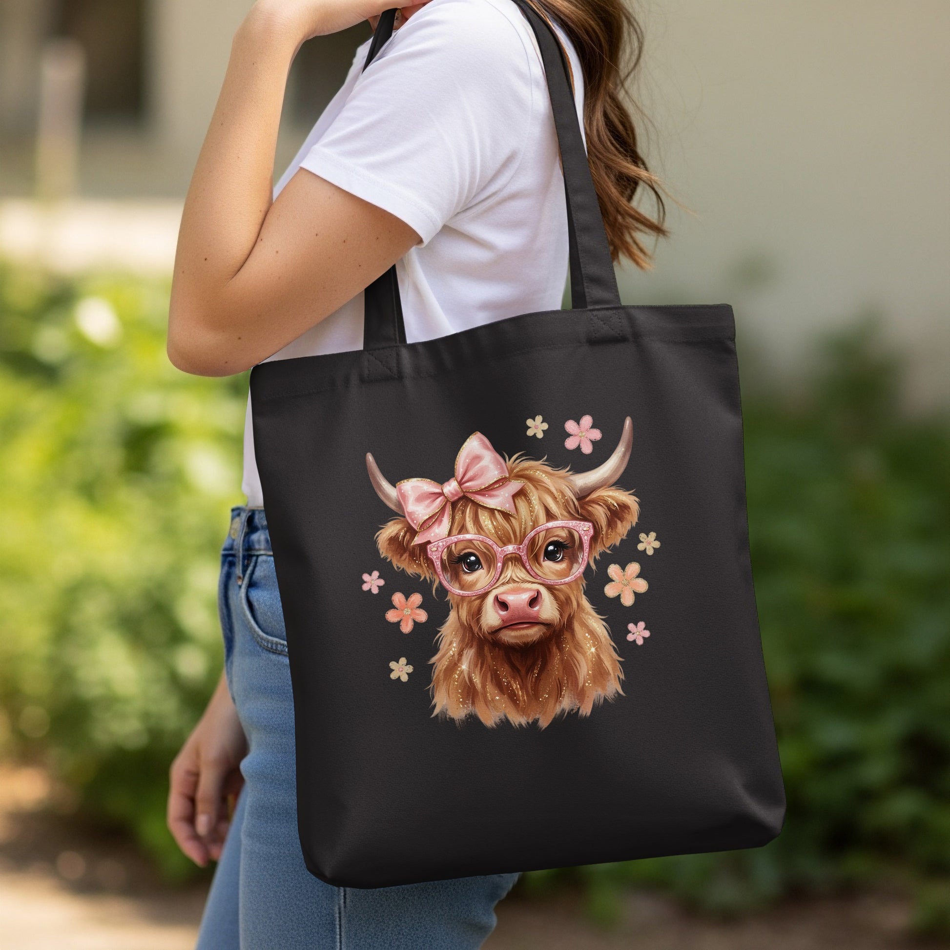 Black tote bag with a cartoon Highland cow wearing glasses and bows.