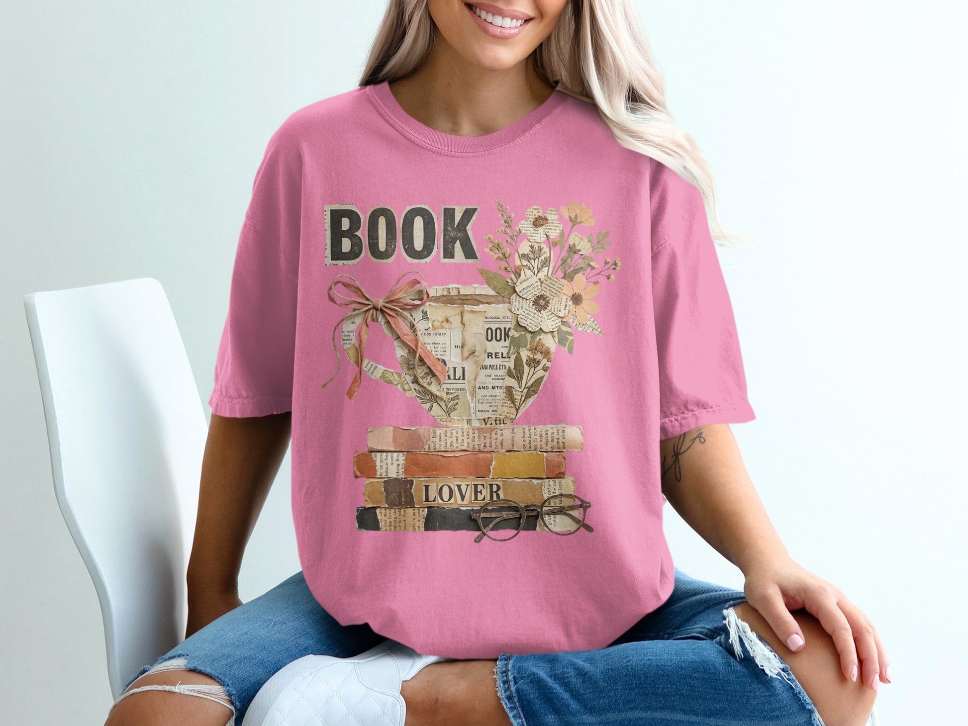 Pink t-shirt with a stack of books, flowers, and glasses design.