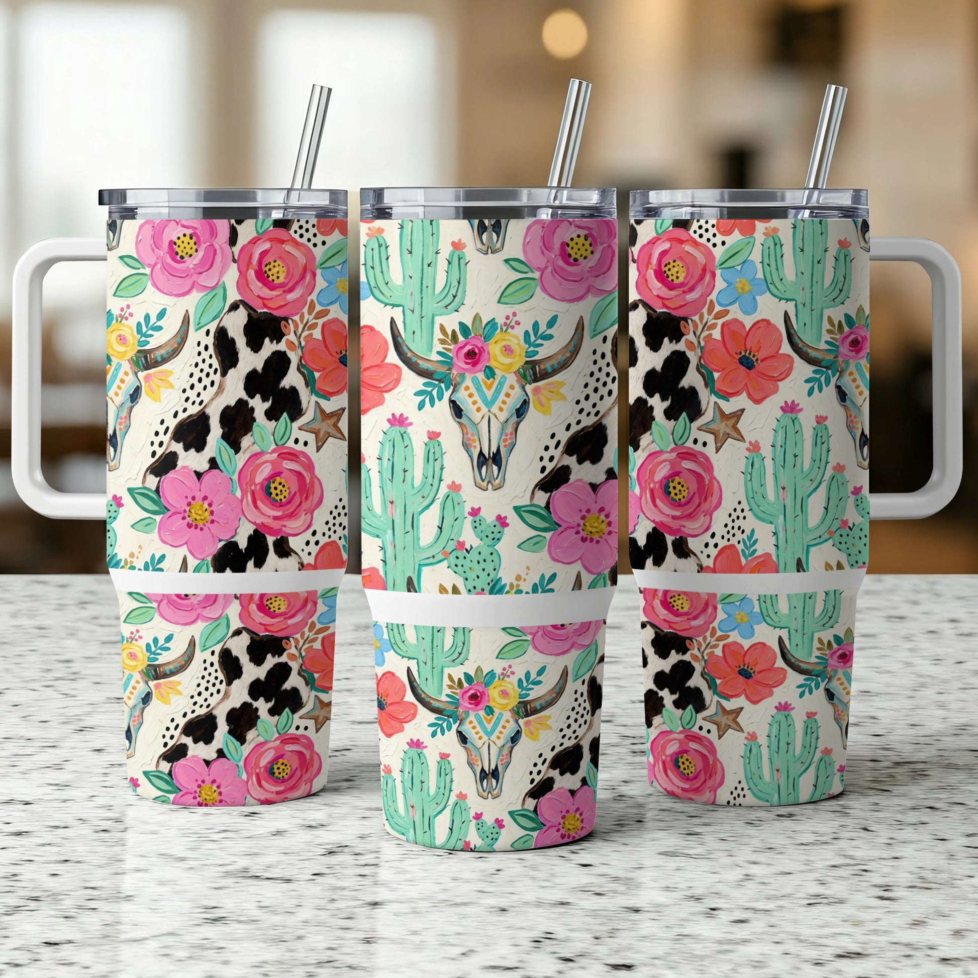 Three tumblers with cow print, cactus, and floral skull designs.