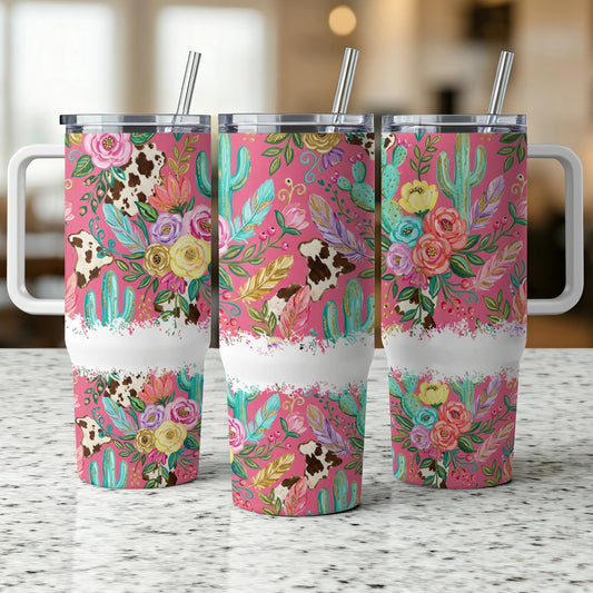 Pink tumbler with cow print and floral desert cactus pattern.