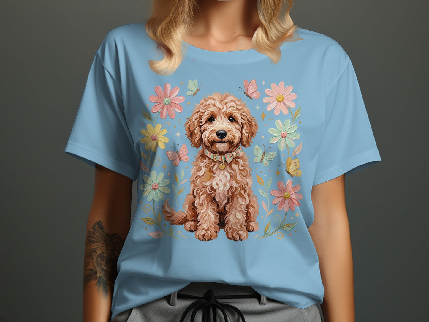 Light blue t-shirt featuring a cartoon doodle dog surrounded by flowers and butterflies.
