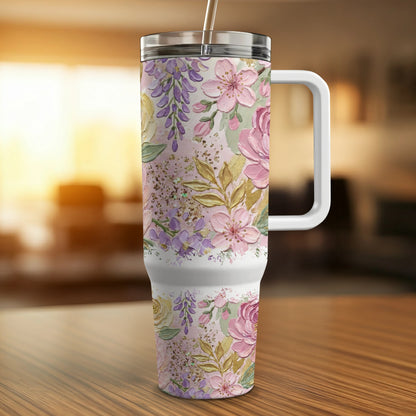 Floral pattern tumbler with straw and handle on a wooden table.