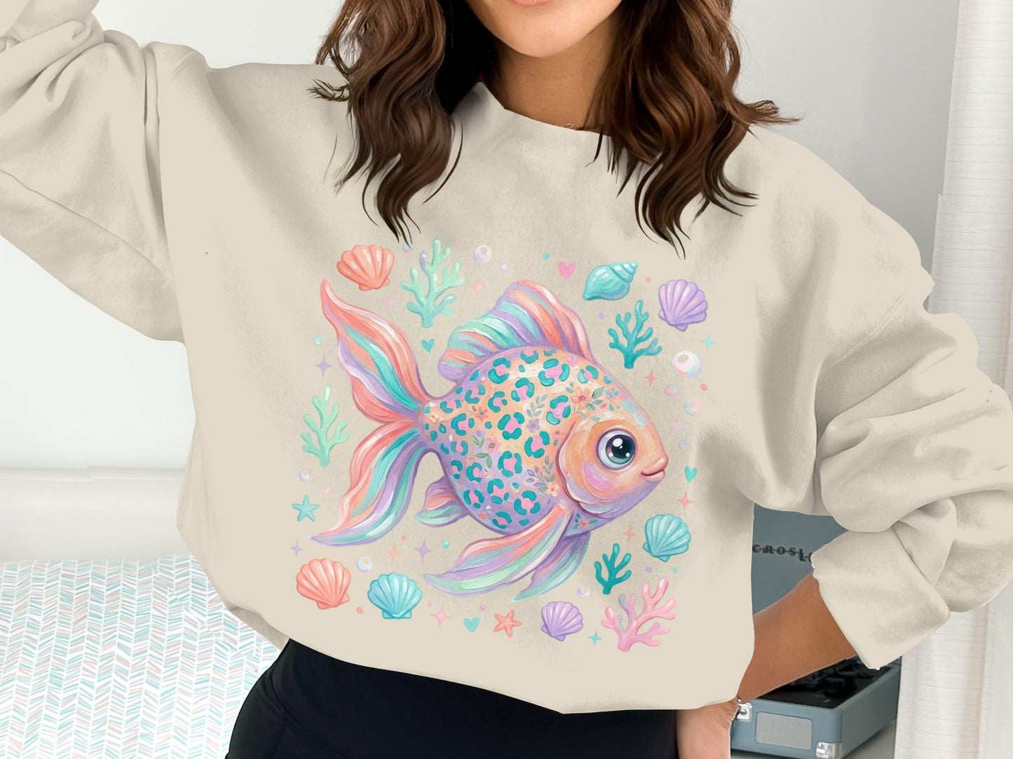Cream sweatshirt with a colorful graphic of a leopard print goldfish and seashells.
