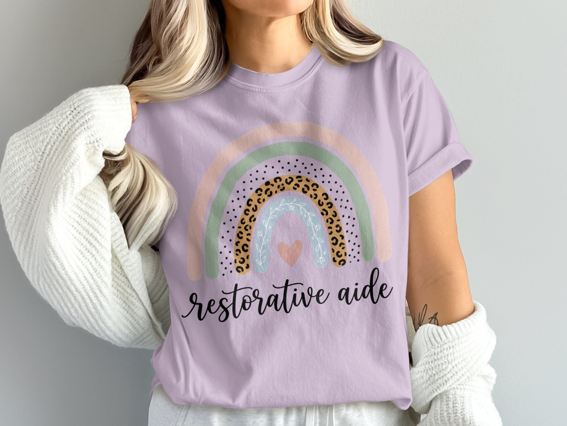 Purple t-shirt with rainbow graphic and "restorative aide" text.