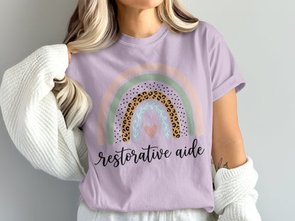 Purple t-shirt with rainbow graphic and "restorative aide" text.