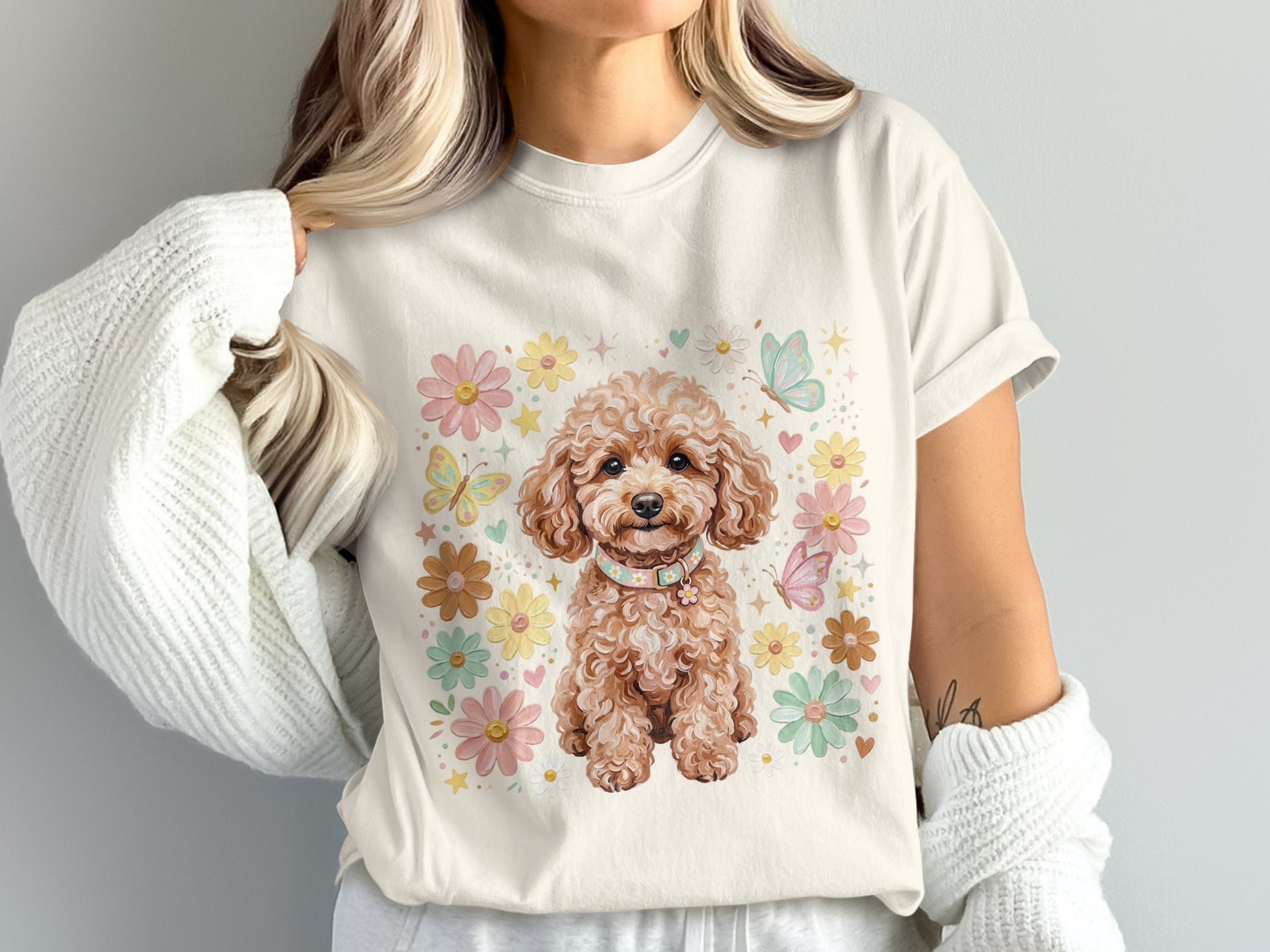 Cream t-shirt with a watercolor poodle surrounded by pastel flowers and butterflies.