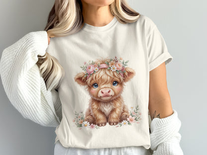 Fluffy Highland cow calf wearing a floral crown, on a light t-shirt.