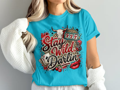 Turquoise t-shirt with "Stay Wild Darlin" text, bull skull, dice, cherries, and lipstick.