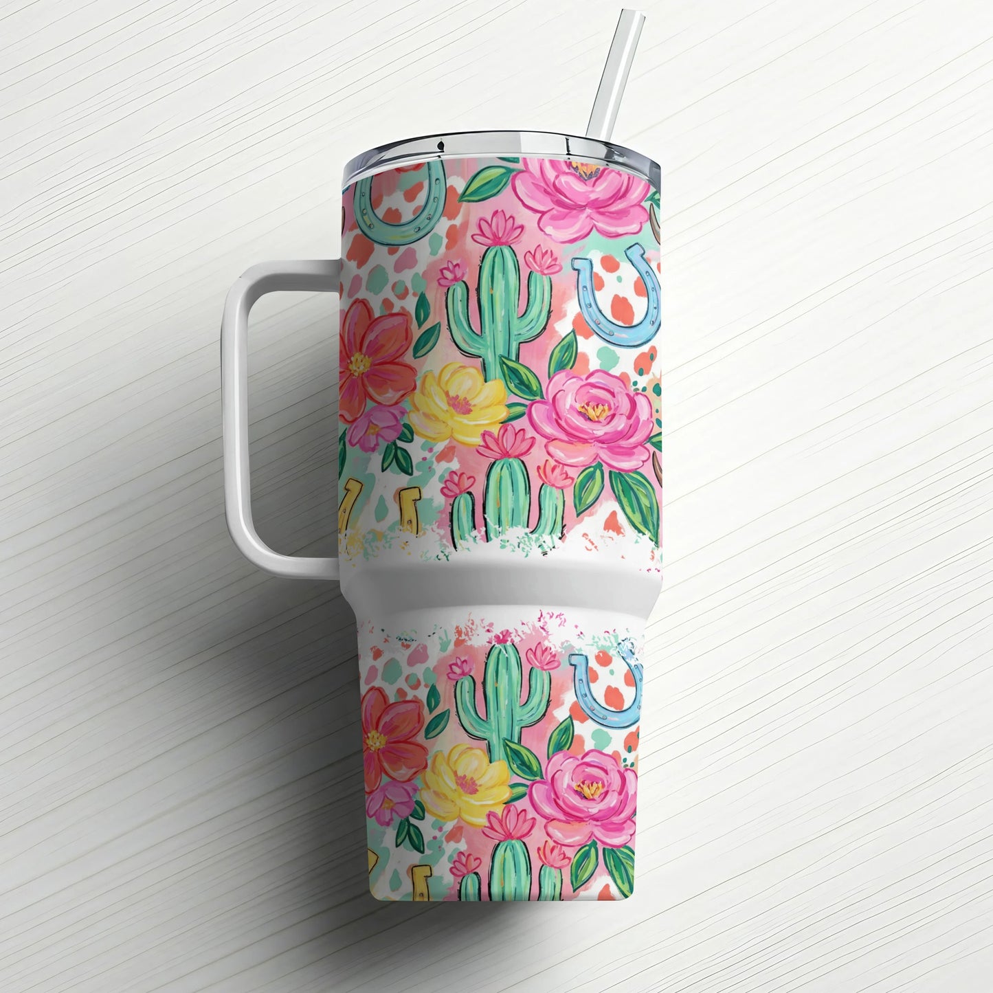 Floral and cactus pattern tumbler with handle and straw.